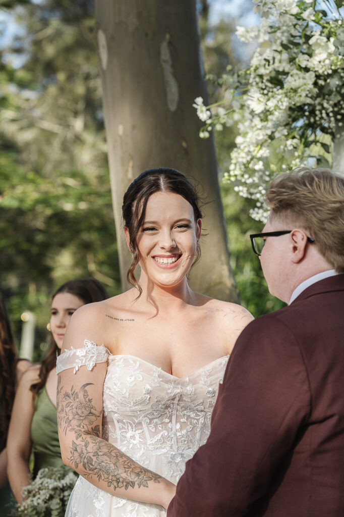 Wedding Ceremony Photography | The Rocks Yandina Bride smiling during her wedding vows at The Rocks Yandina, captured by a Sunshine Coast wedding photographer.