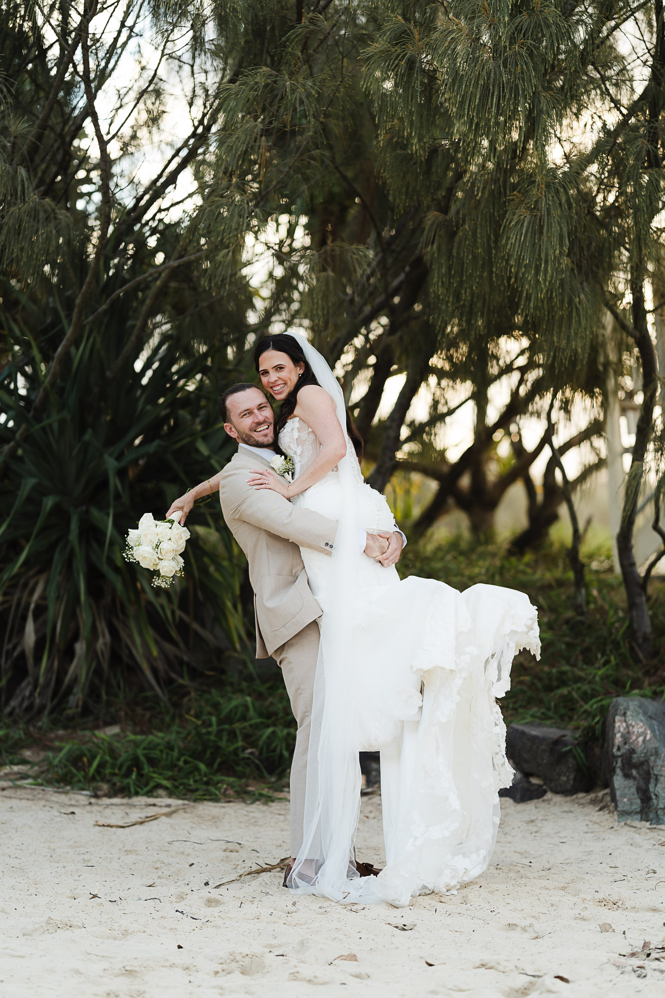 Luxury coastal wedding portrait of a bride and groom at sunset on Noosa Beach, captured by a Sunshine Coast wedding photographer and videographer.