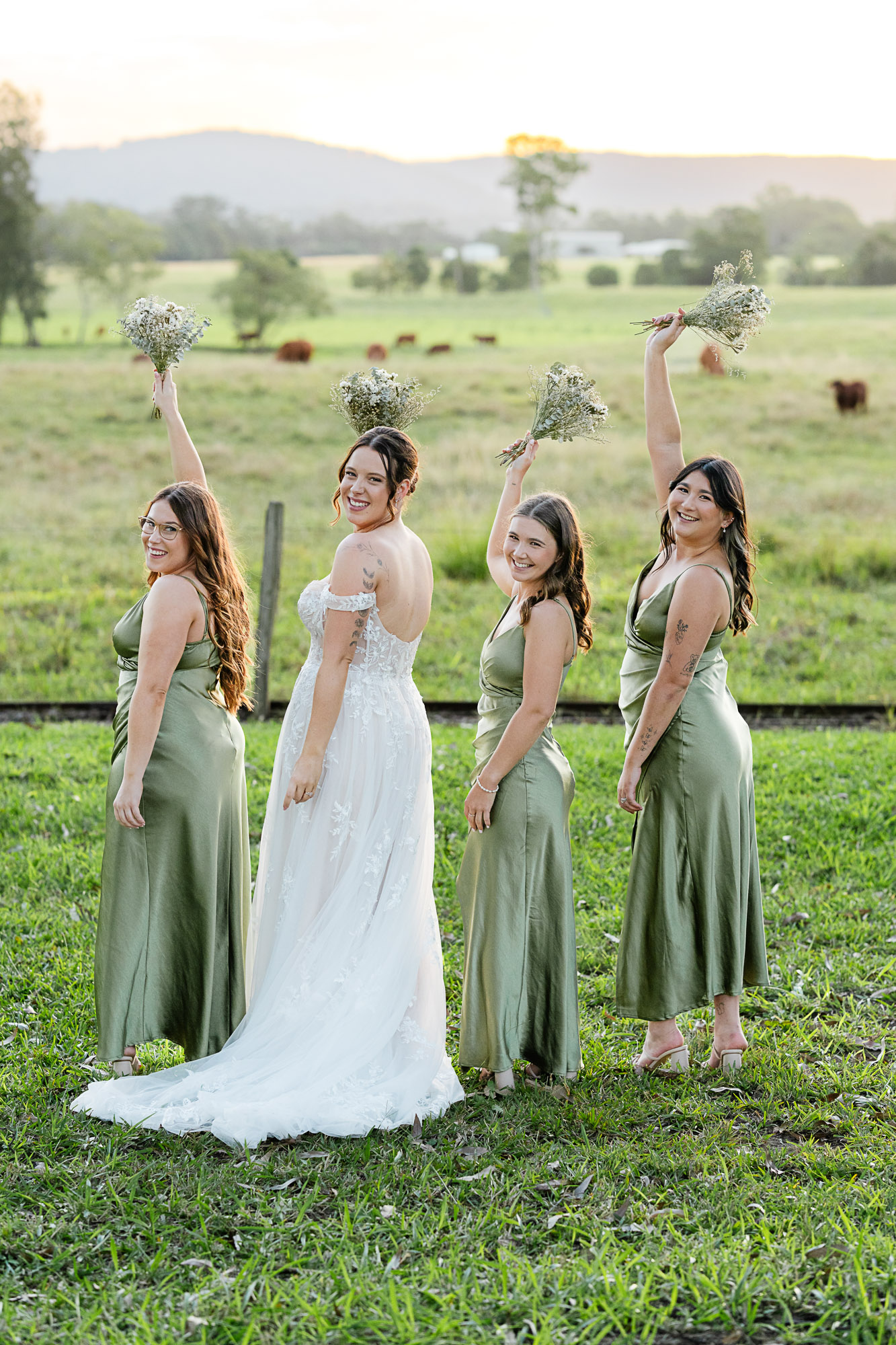 High-energy candid bridal party portrait of a bride celebrating with her bridesmaids at The Rocks in Yandina on the Sunshine Coast, captured through luxury wedding photography and cinematic videography.