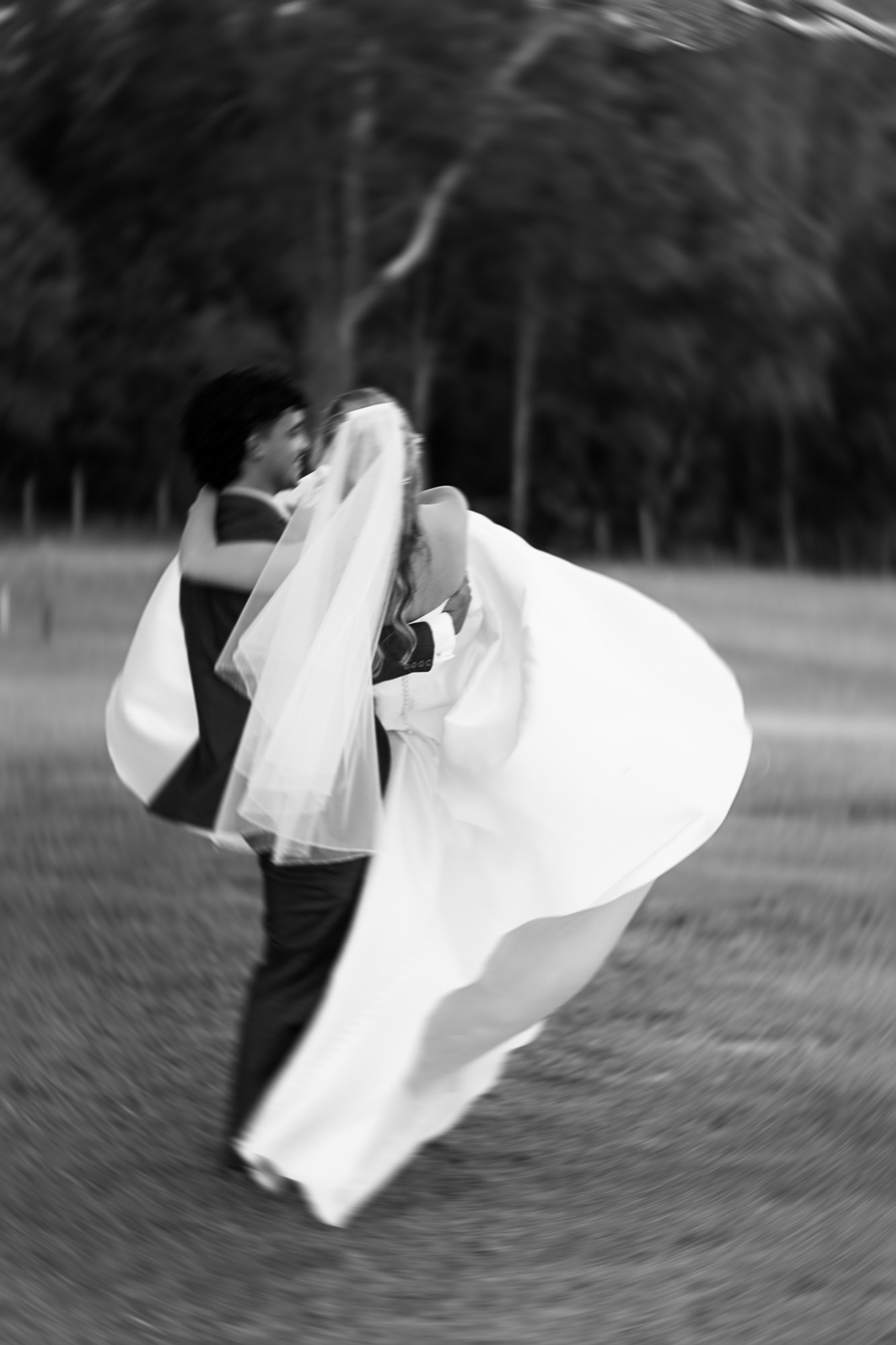 Documentary-style wedding portrait with creative motion blur of newlyweds at Yandina Station on the Sunshine Coast, captured through luxury wedding photography and cinematic videography during summer.