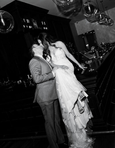 Bride and groom posing together on top of a bar during their wedding reception, captured by a Sunshine Coast wedding photographer and videographer.
