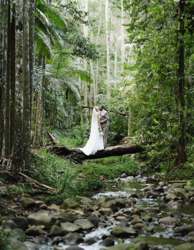 Bride and groom surrounded by lush green rainforest during their wedding portraits at Buderim Waterfall on the Sunshine Coast.