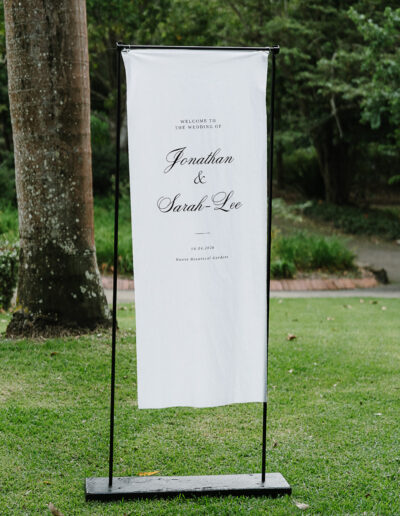 Wedding welcome sign displayed at a ceremony at Noosa Botanic Gardens, photographed by a Noosa wedding photographer.